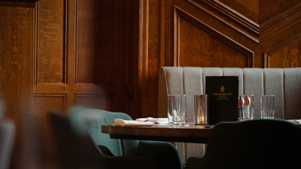Elegant dining table with plush chairs and candlelit setting, offering a cosy dining experience at the hotel restaurant.
