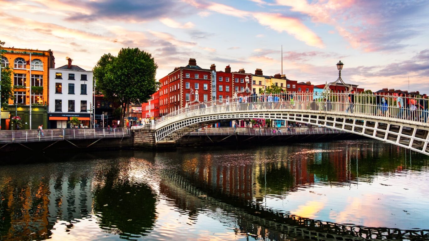Night view of famous illuminated Ha Penny Bridge in Dublin, Ireland at sunset