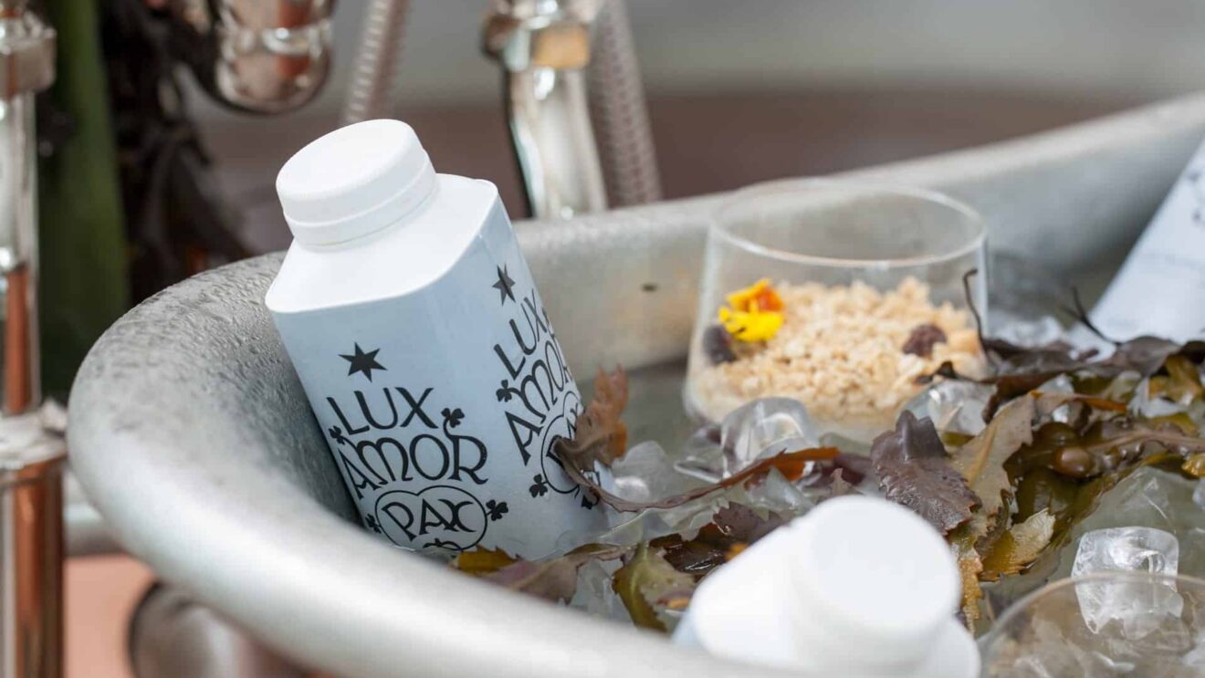 Eco-friendly guest amenities in a luxurious hotel bathroom with organic bath products, seaweed, and fresh ice.