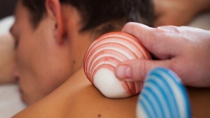 Relaxing spa massage with warm, smooth shells at luxury hotel, promising a serene and rejuvenating experience.