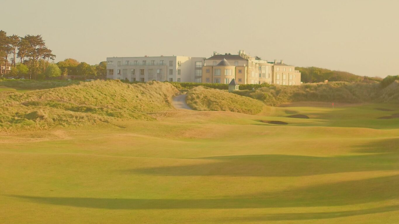 Scenic view of luxury hotel with nearby golf course, lush greenery, and tranquil atmosphere, ideal for a relaxing getaway.