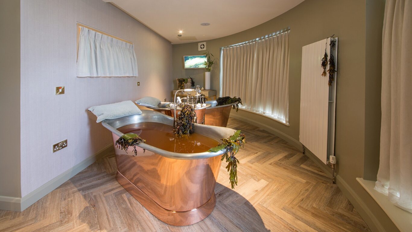 Luxurious copper bathtubs with relaxing seaweed decor in a serene spa setting at a stylish hotel retreat.
