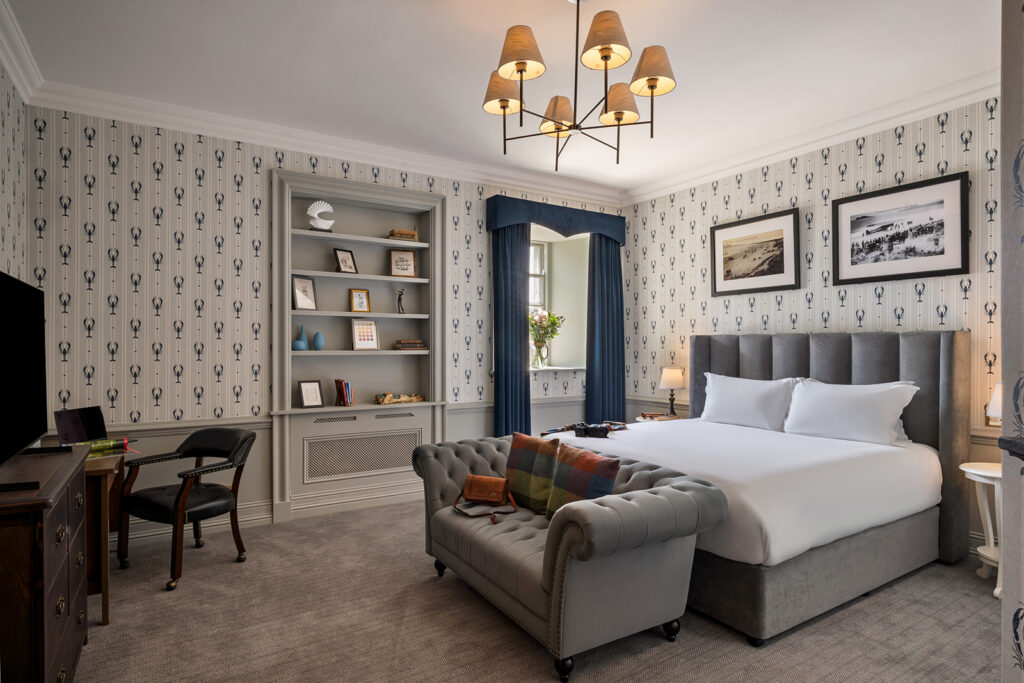 Elegant Hotel Room Interior Elegant hotel room with king-size bed, cosy sofa, classic decor, desk, and window view. Enjoy a relaxing stay.