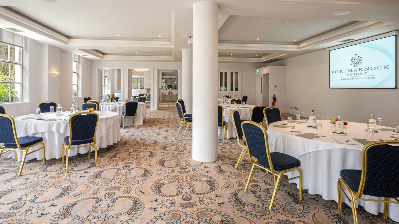 Elegant conference room at Portmarnock Resort with round tables set for events, showcasing stylish decor and modern amenities.