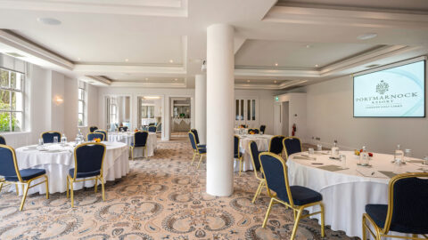 Elegant conference room at Portmarnock Resort with round tables set for events, showcasing stylish decor and modern amenities.