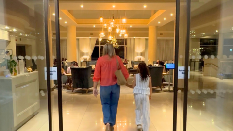 Guests enter a welcoming hotel lobby with elegant lighting, plush seating, and a warm atmosphere.