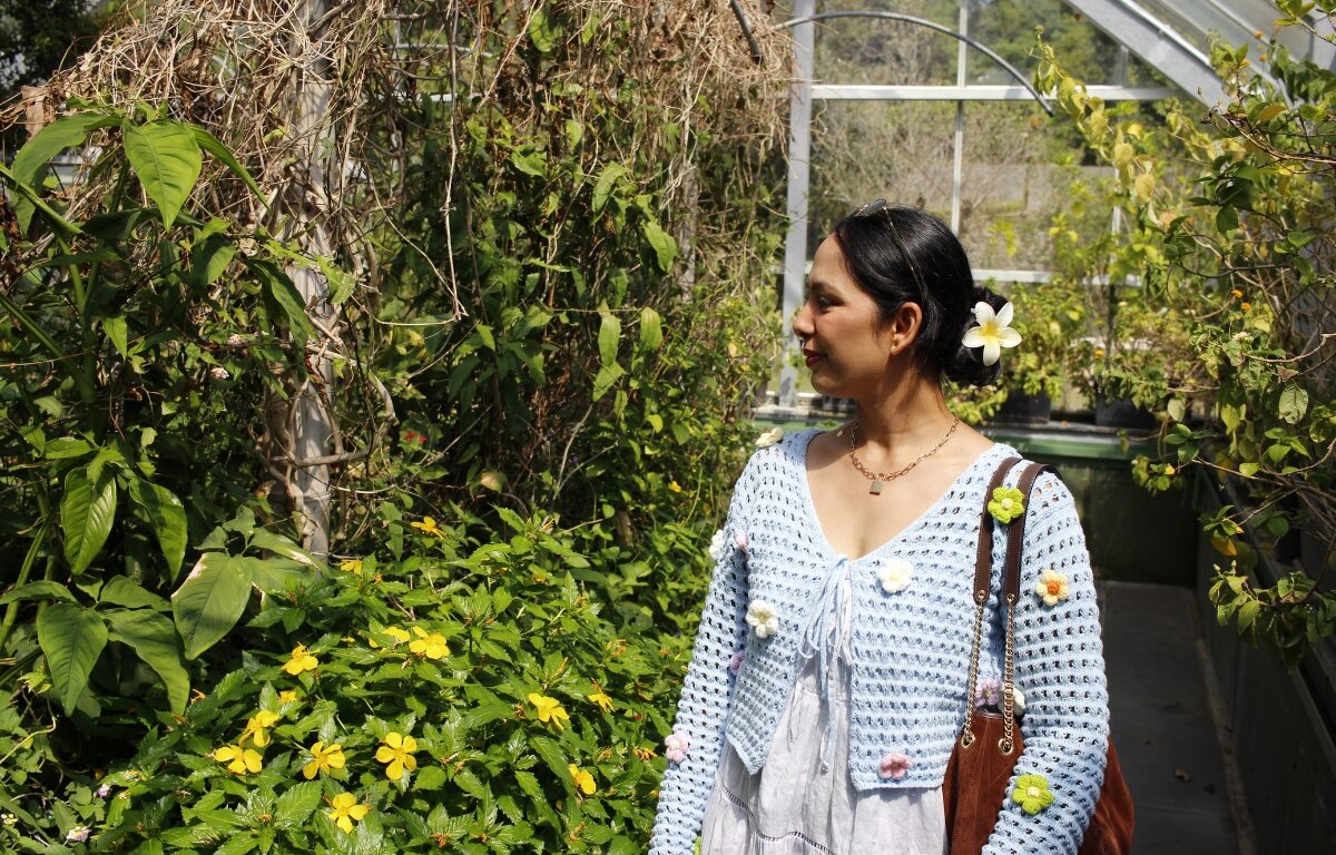 Woman in botanical garden with vibrant greenery, enjoying serene hotel amenities and nature’s beauty.